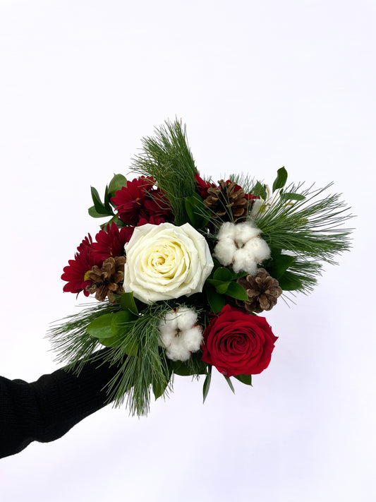 Bouquet “Flocons Rouges et Blancs” avec roses rouges et blanches, gerberas rouges, branches de pin, coton naturel, pommes de pin et feuillages décoratifs.